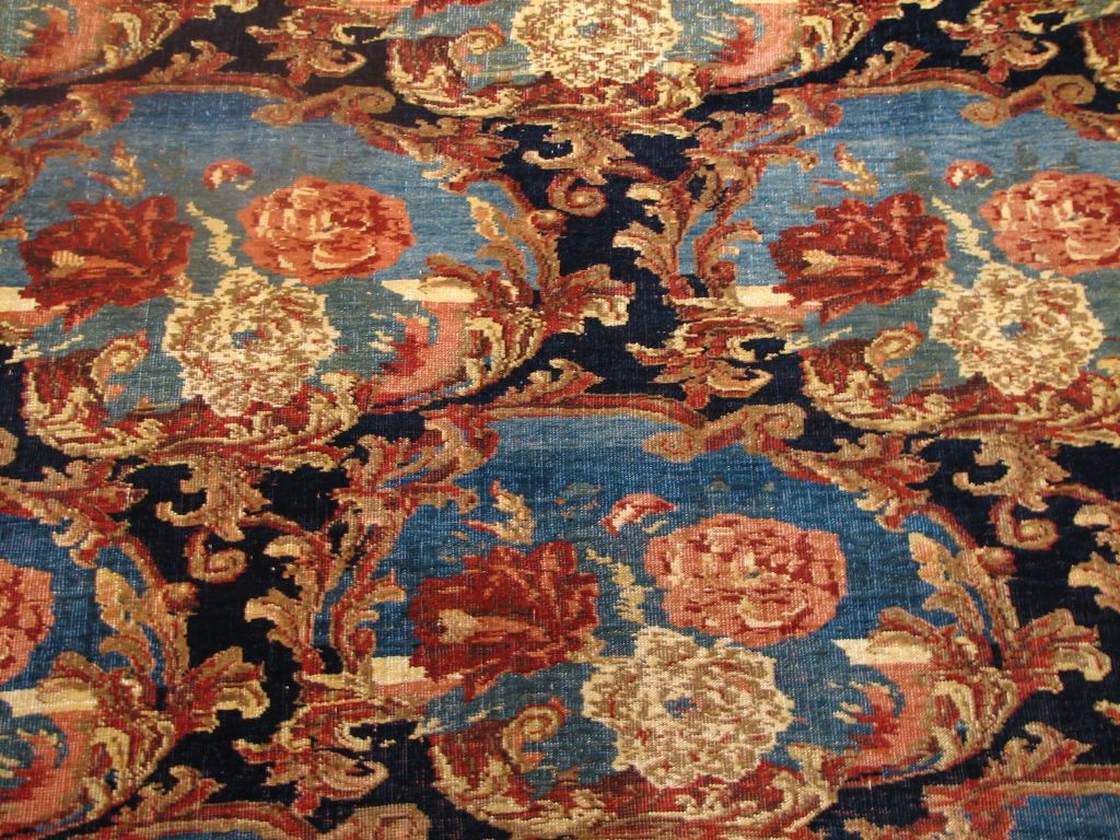 Detail of antique Bijar rug; handwoven floral pattern in deep blues, reds, and golds.