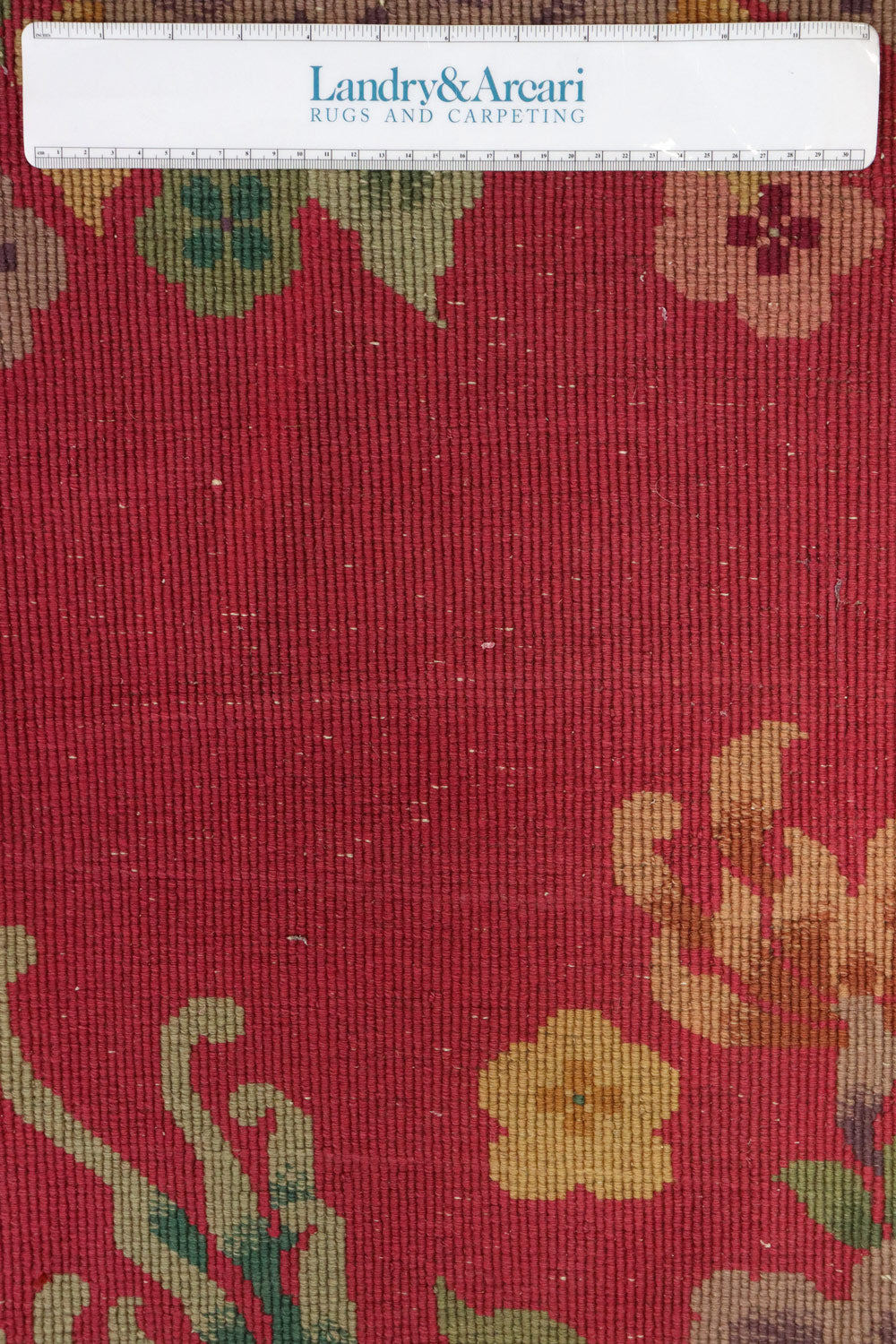 Close-up of a red Art Deco rug with a floral pattern, showcasing its handwoven texture.