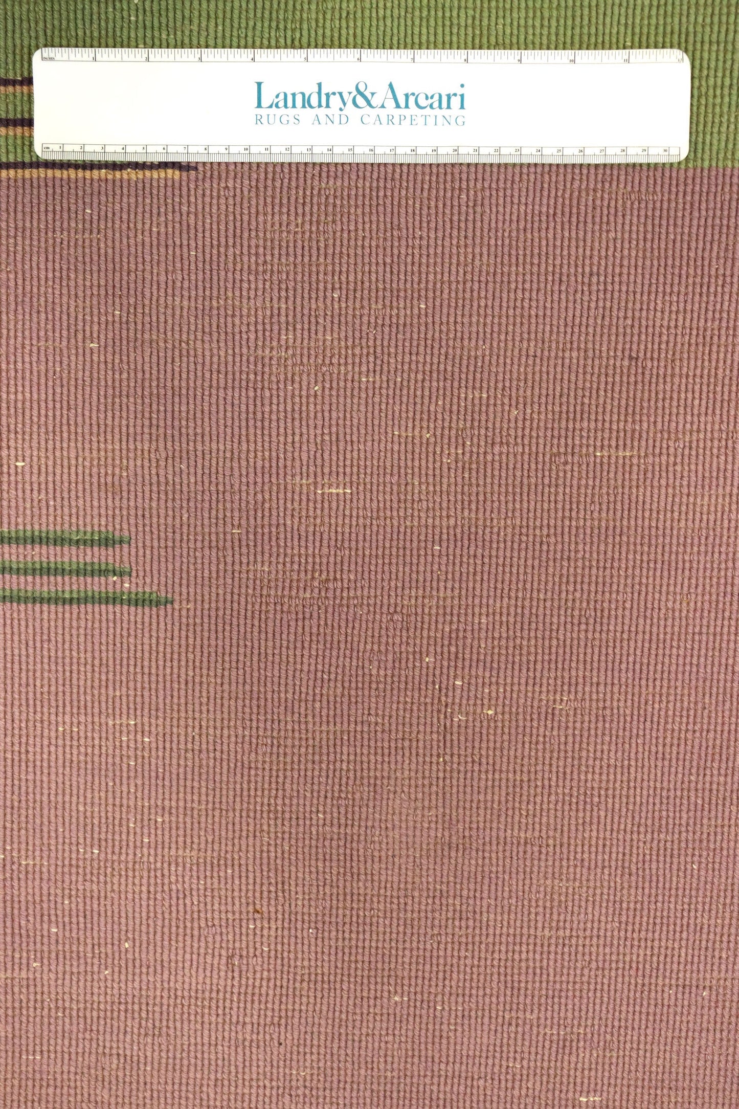 Close-up of mauve Art Deco rug detail, showing textured weave and subtle green accents.
