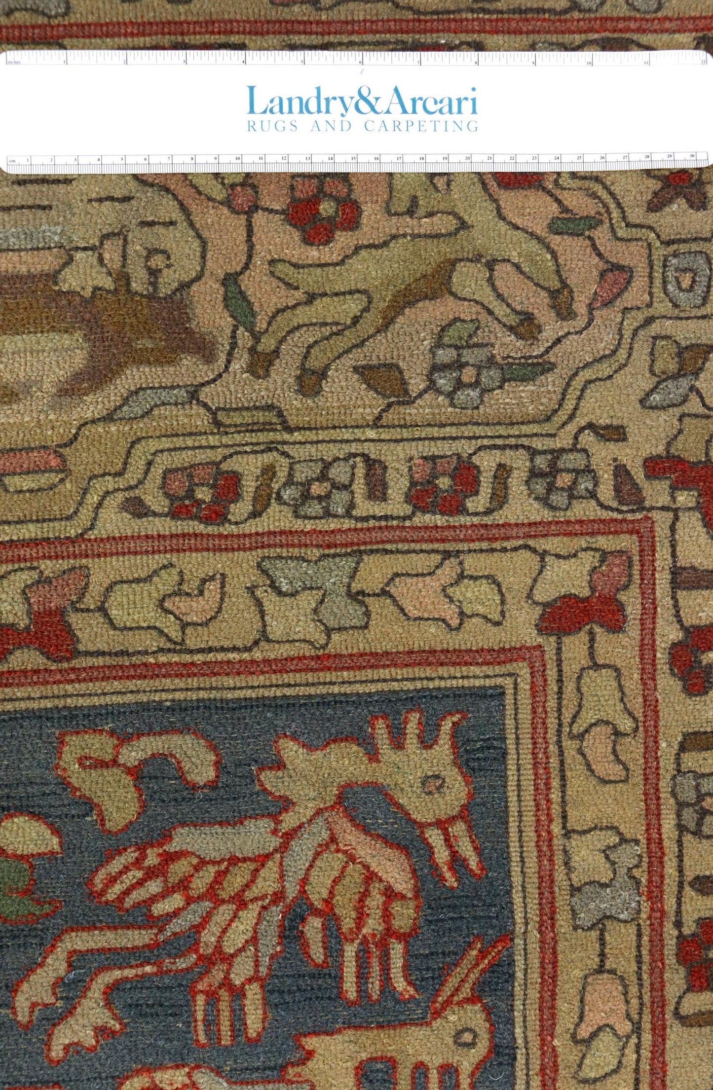 Detailed close-up of antique German hooked rug, showcasing traditional handwoven design and muted color palette.
