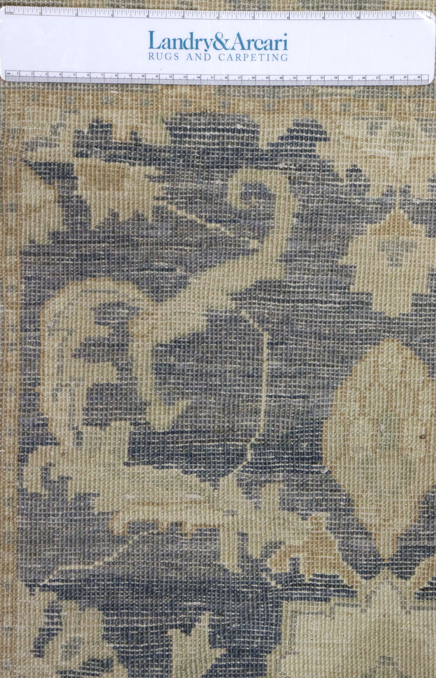 Close-up of handwoven rug detail, showcasing a beige and blue transitional design.