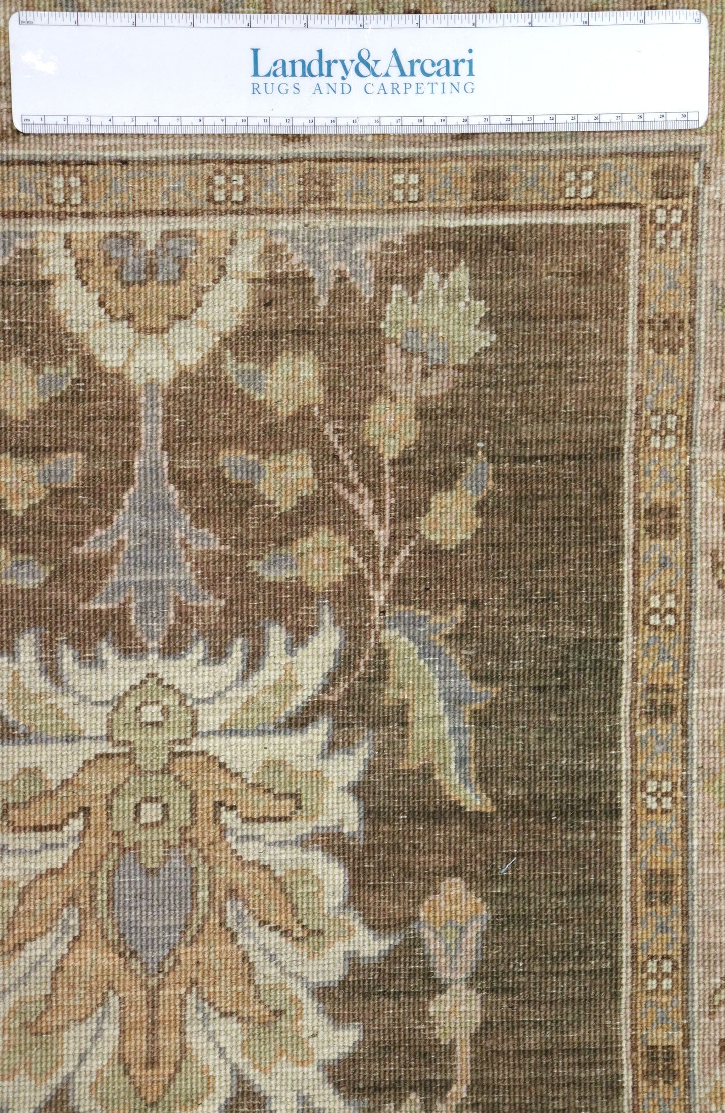 Close-up of handwoven rug detail; earthy tones, intricate floral pattern, transitional style.