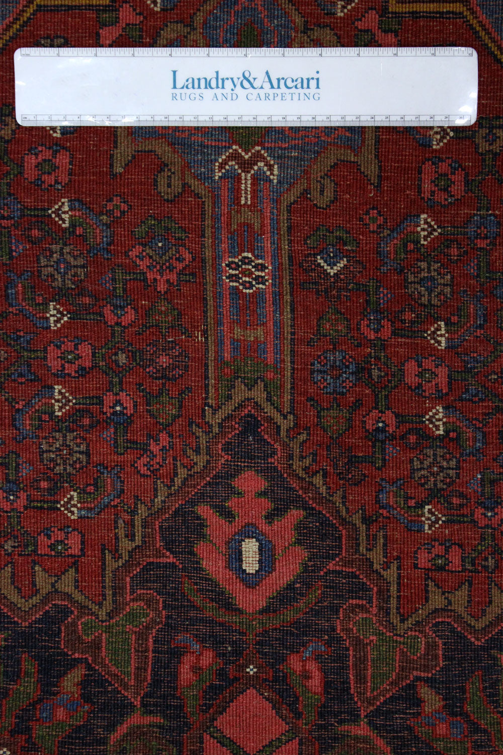 Close-up detail of antique Bijar rug's intricate, handwoven pattern in rich reds and deep blues.