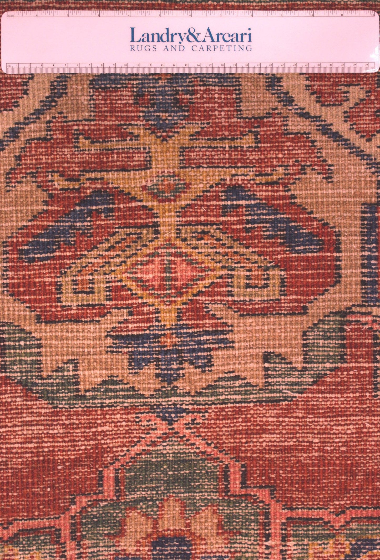 Close-up detail of antique Heriz rug's handwoven pattern; red, beige, and blue tones.