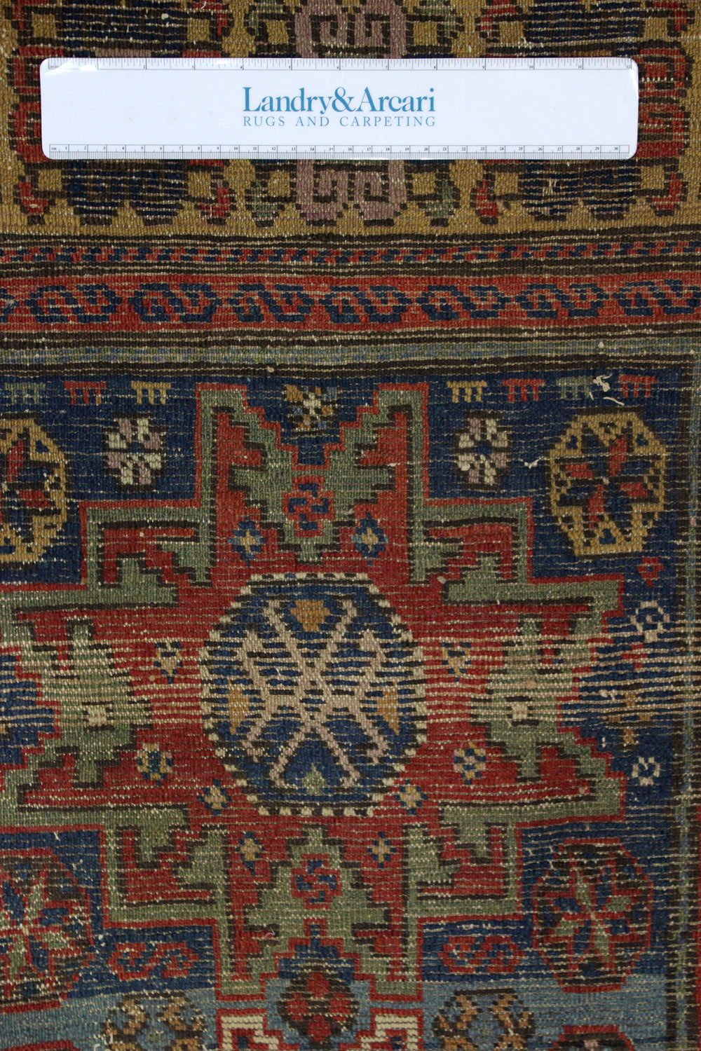 Detail of antique Lesghi rug, showcasing handwoven, multicolored geometric patterns.