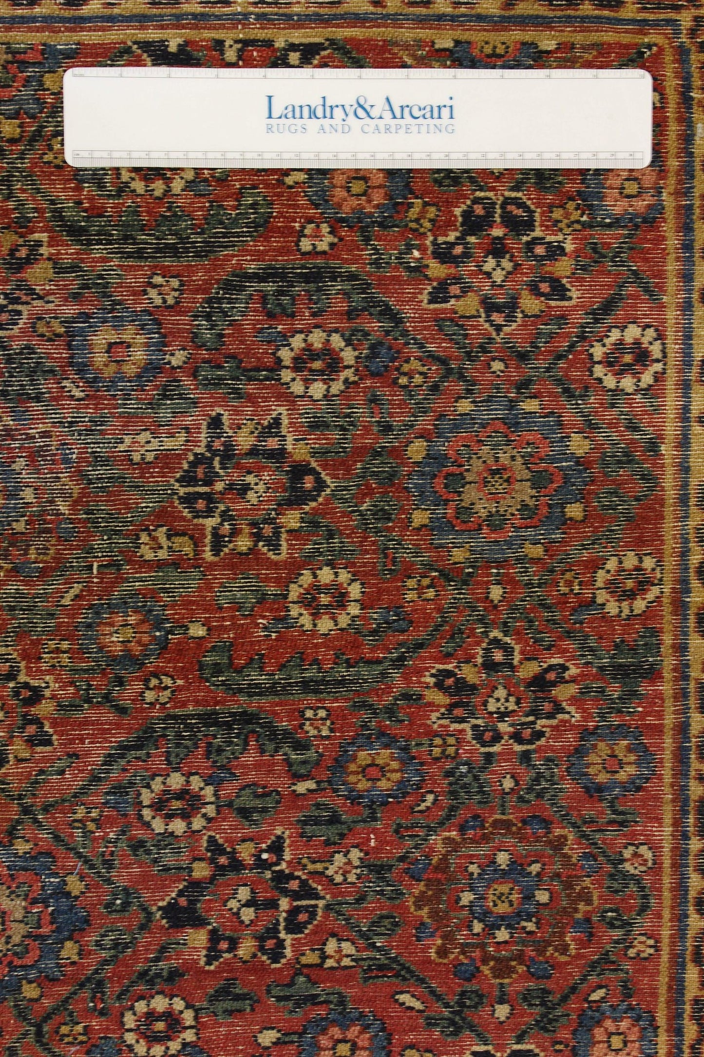 Antique Persian rug detail: rich red, blue, and green floral pattern, handwoven texture.