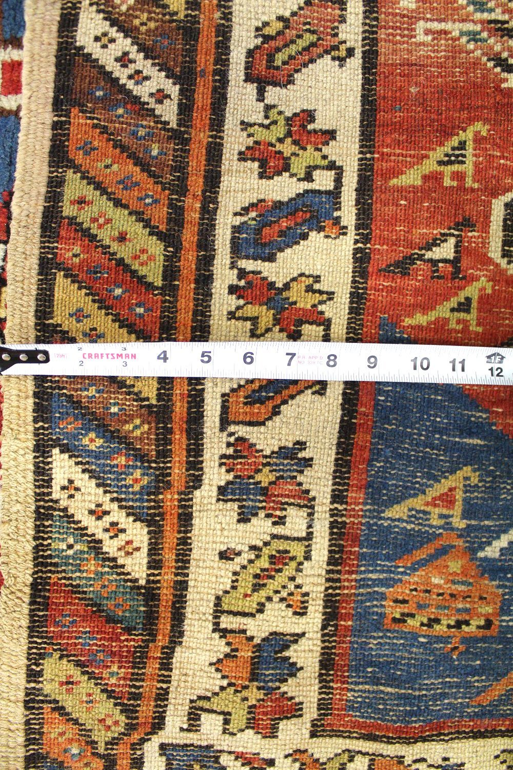 Antique Persian tribal rug detail, showcasing vibrant colors and intricate patterns.