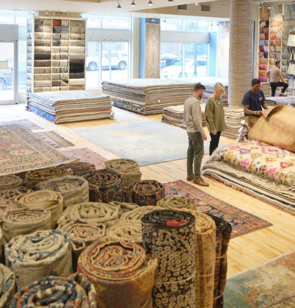 Landry and Arcari Showroom with stacks of oriental rugs and carpet in Boston