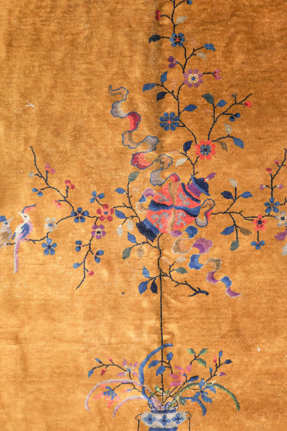 Handwoven Art Deco rug in gold, detailed with a floral motif and birds.
