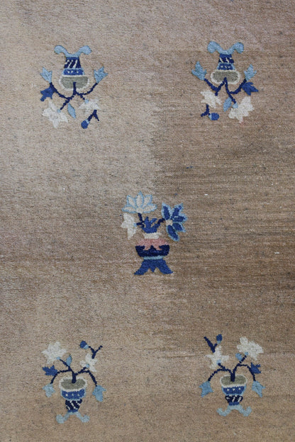 Handwoven antique Peking rug detail: Beige background with blue and white floral motifs.
