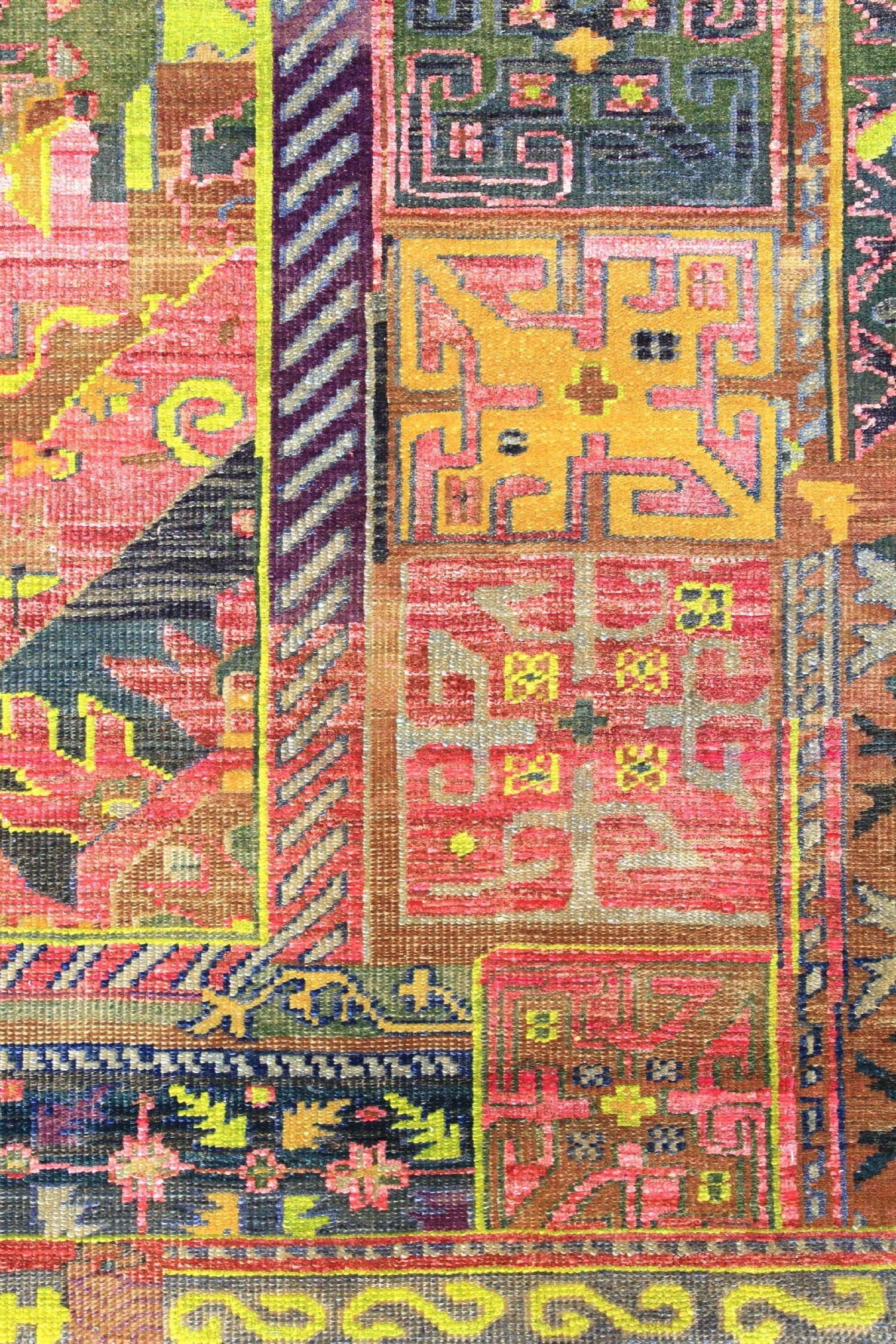 Handwoven rug detail, showcasing a vibrant multicolored pattern with geometric and floral motifs.
