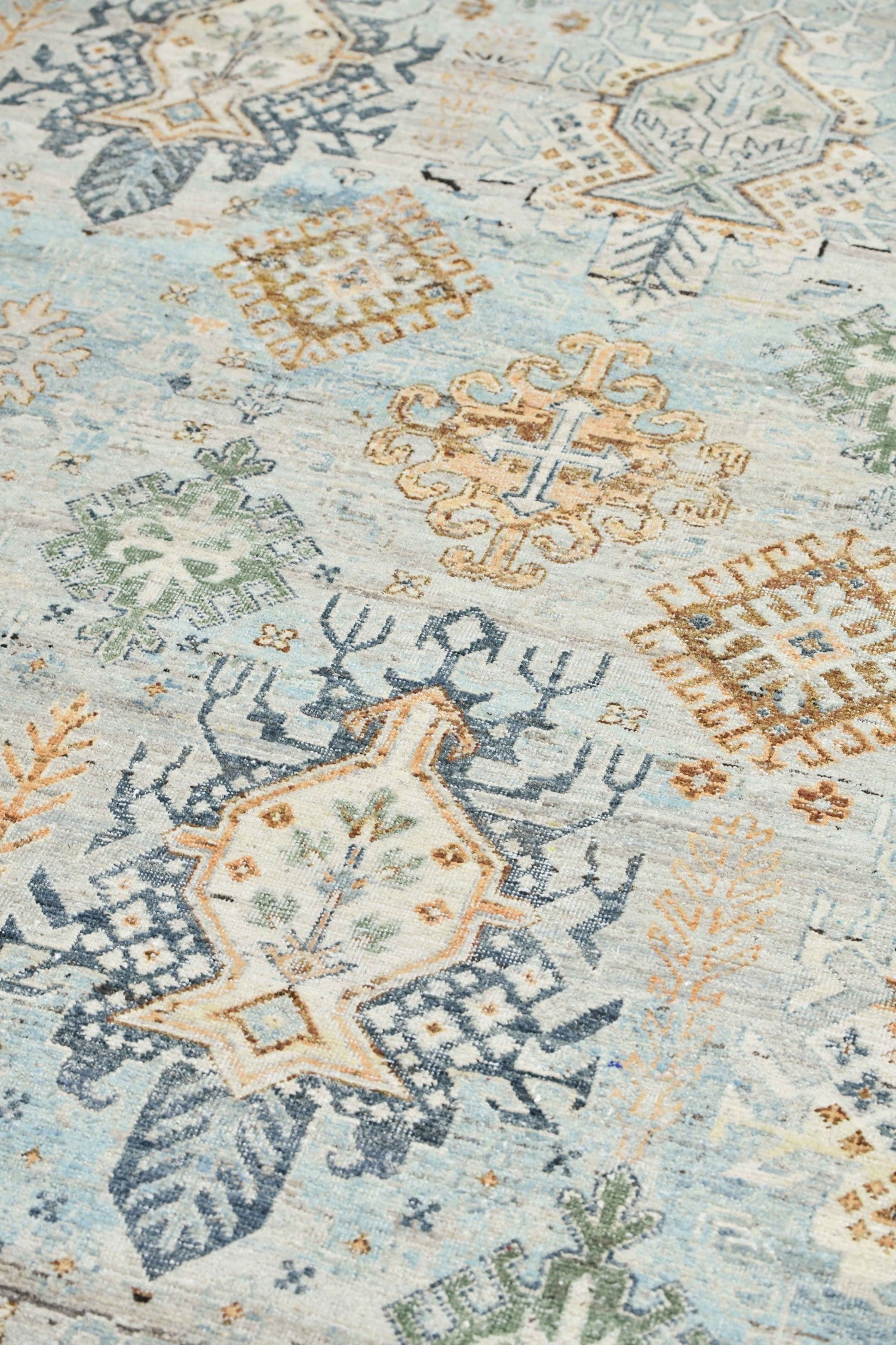 Handwoven rug detail: Blue, beige, and green patterned design.
