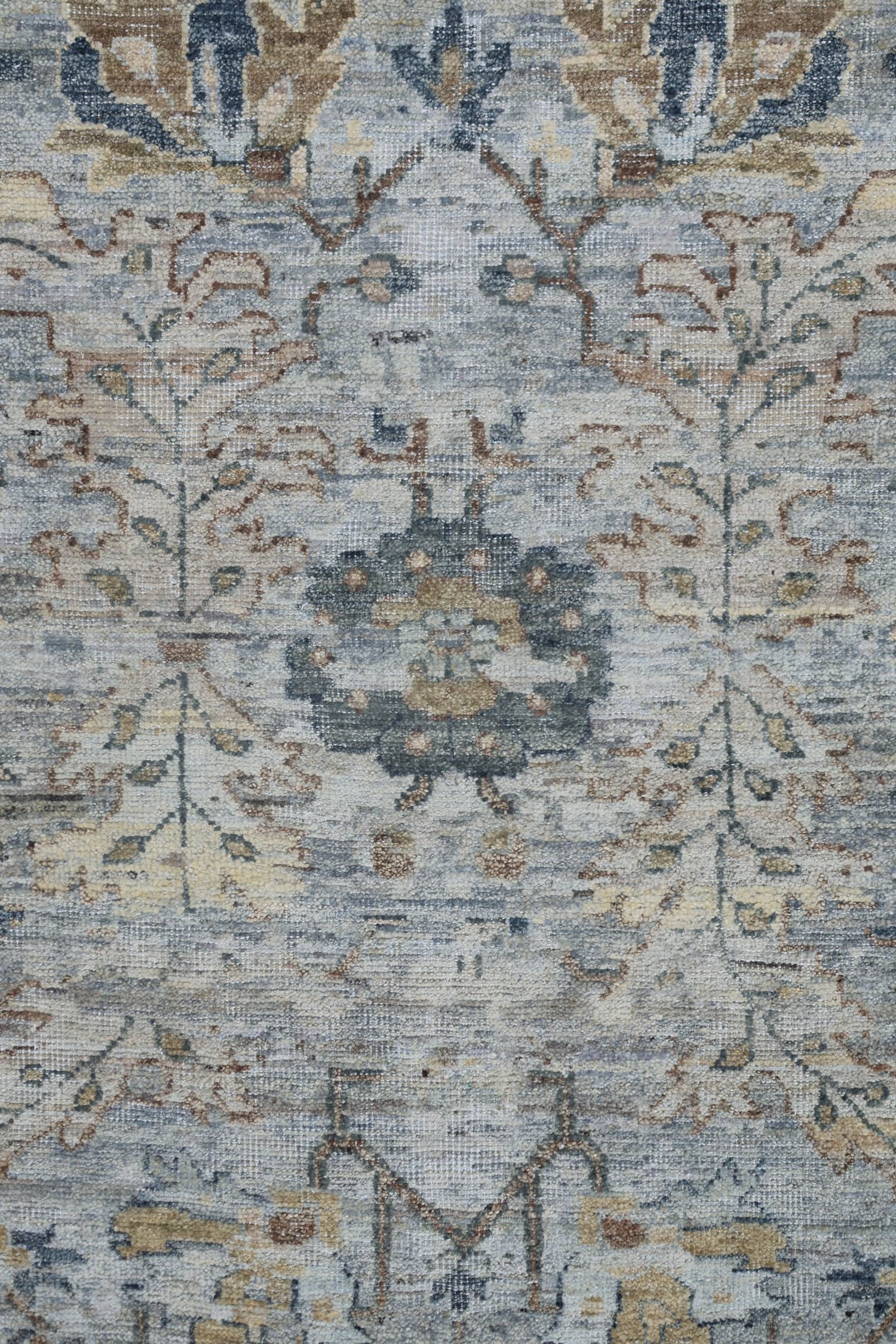 Handwoven rug detail, featuring a transitional Serapi design in muted blues and beige tones.
