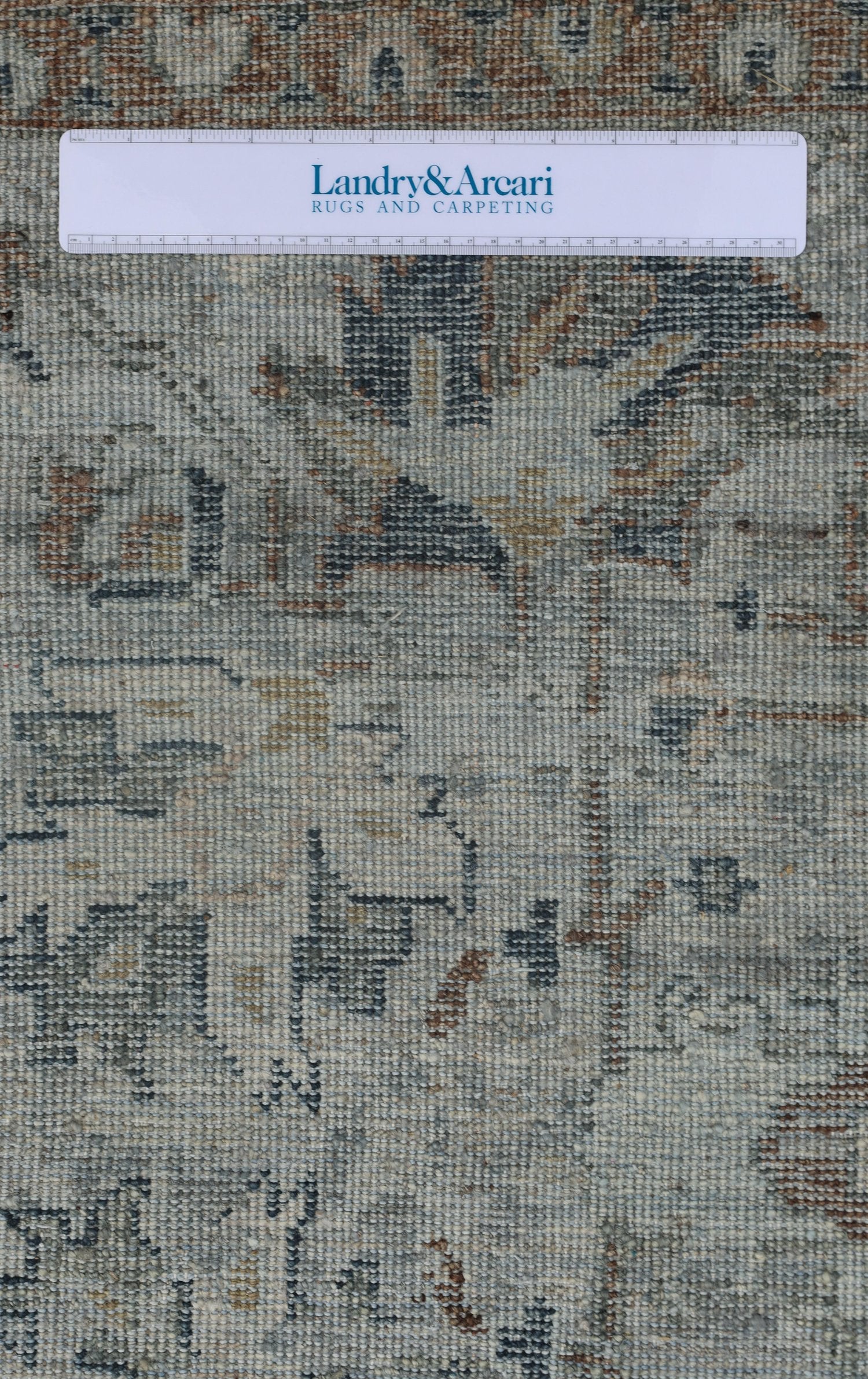 Close-up detail of a handwoven rug, showcasing its neutral color palette and intricate texture.
