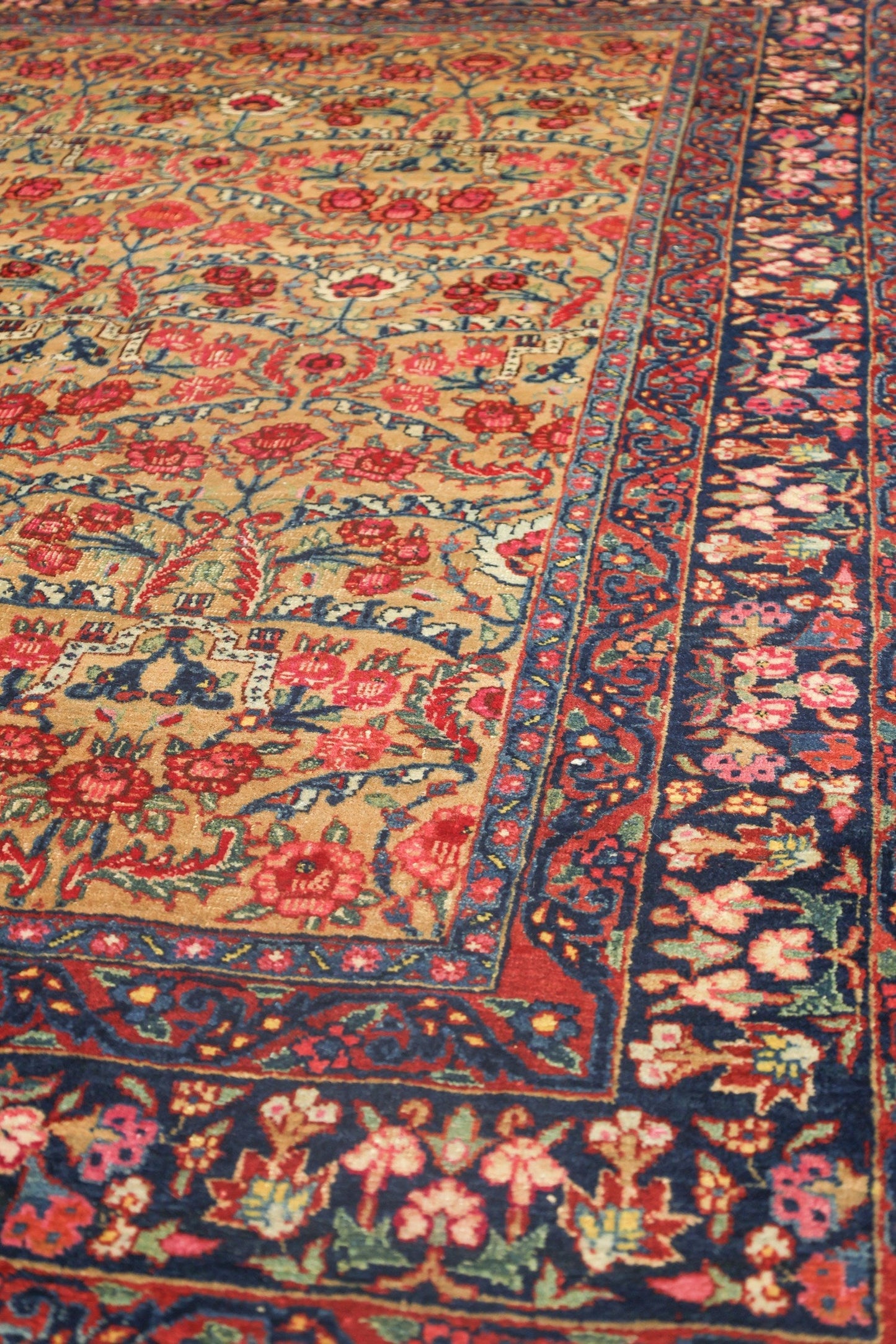 Antique Bijar rug detail: handwoven floral pattern in red, blue, and beige.
