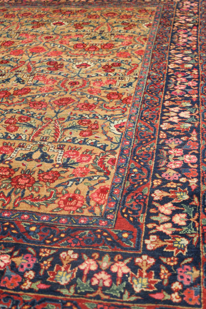 Antique Bijar rug detail: handwoven floral pattern in red, blue, and beige.
