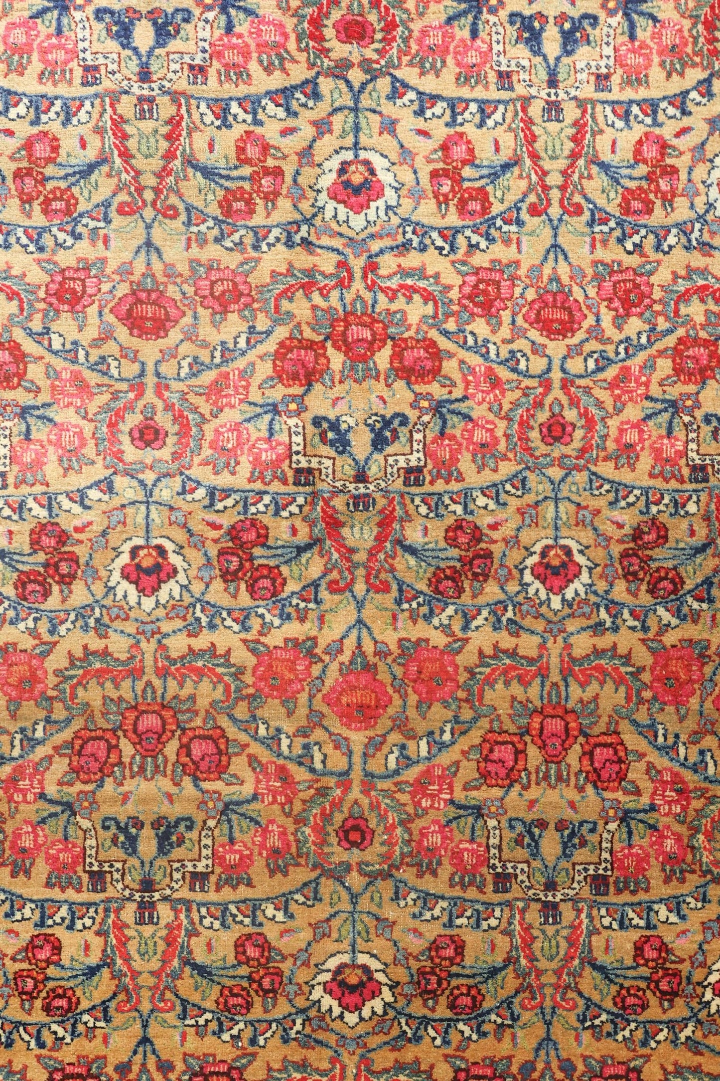 Antique rug detail:  Handwoven Bijar tribal design with floral and botanical motifs in red, blue, and beige.
