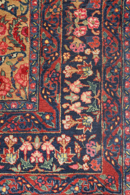 Handwoven rug detail: intricate floral pattern in red, blue, and beige.
