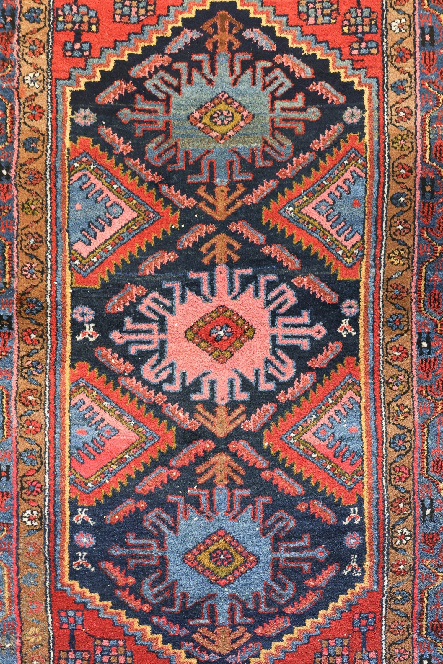 Handwoven tribal rug detail: rich reds, blues, and intricate geometric patterns.
