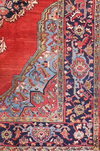 Detail of antique Heriz rug's handwoven border, showcasing vibrant red, blue, and floral patterns.
