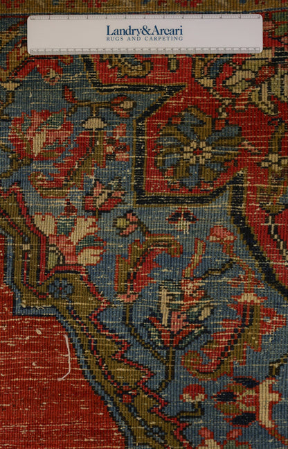 Close-up detail of antique Heriz rug showcasing intricate handwoven pattern in red, blue, and gold tones.
