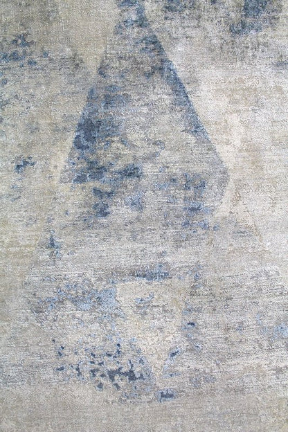 Handwoven rug detail:  blue and beige abstract pattern on a textured surface.
