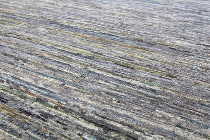 Handwoven rug detail: grey, blue, and yellow tones in a contemporary striped pattern.
