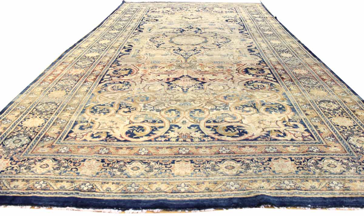 Antique medallion rug, handwoven with intricate navy and beige floral patterns.
