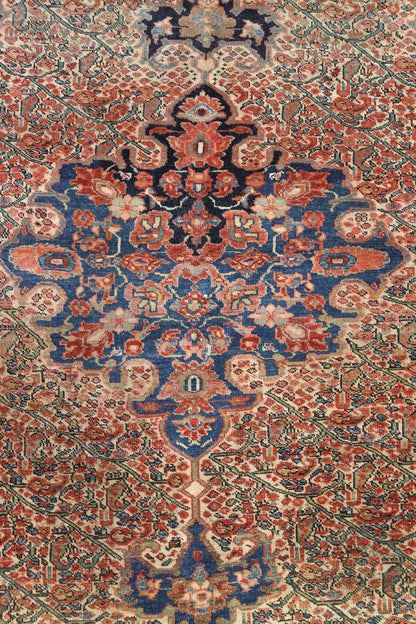 Intricate detail of antique handwoven rug in red, blue, and beige.
