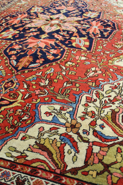 Detail of antique Ferahan Sarouk rug, showcasing handwoven floral pattern in red, blue, and ivory.
