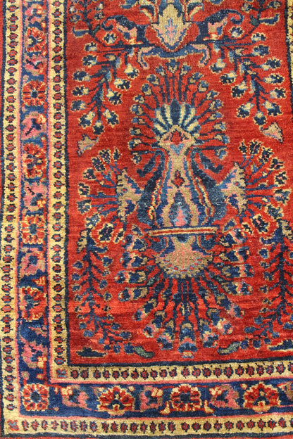 Handwoven Lilihan rug detail: rich red and blue floral pattern, antique design.
