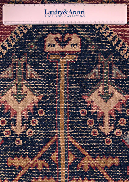 Close-up detail of antique Bakhtiari rug's intricate, handwoven pattern in rich navy, beige, and red tones.
