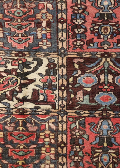 Detailed close-up of antique rug's handwoven tribal design, showcasing rich reds, blues, and creams.

