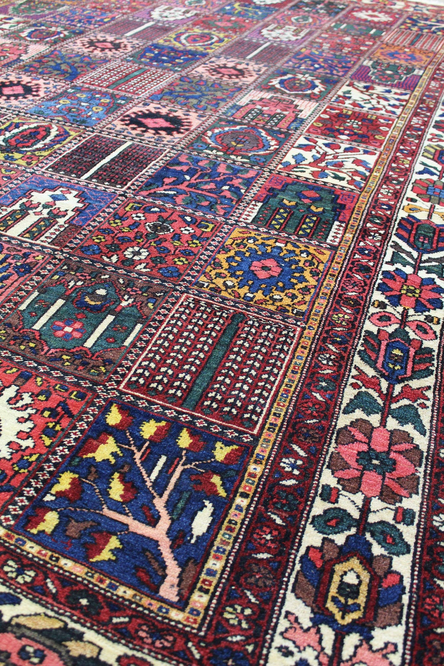Detail of a handcrafted Bakhtiari rug, showcasing vibrant red, blue, and gold patterns.
