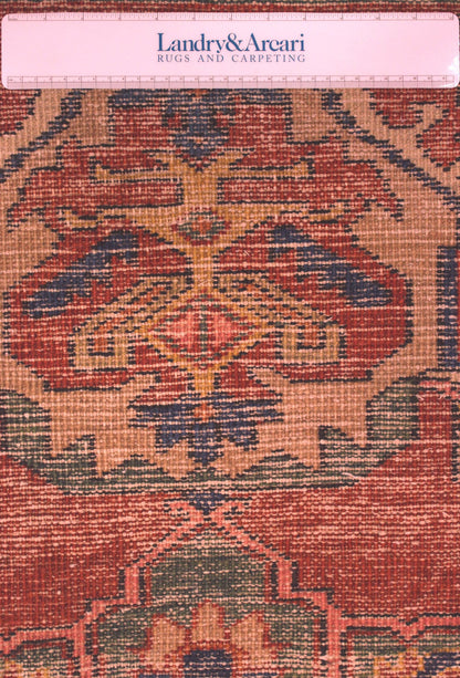 Close-up detail of antique Heriz rug's handwoven pattern; red, beige, and blue tones.
