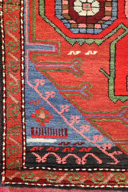 Handwoven rug detail: vibrant red, blue, and green patterns, intricate tribal design.
