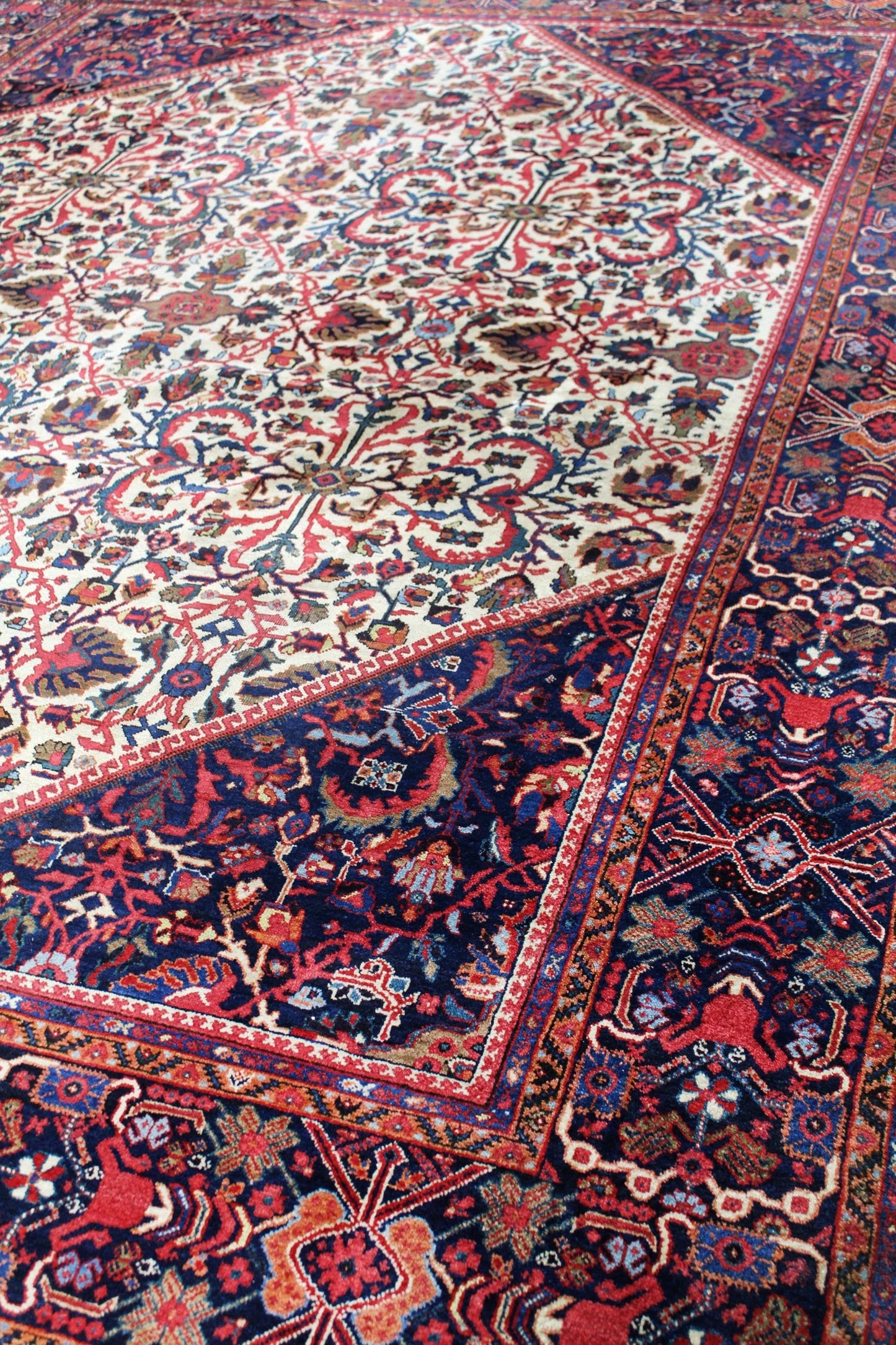 Handwoven tribal rug detail: rich red, navy, and cream pattern.
