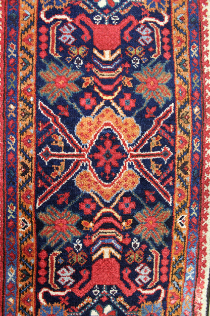 Handwoven tribal rug detail, rich red and navy pattern.
