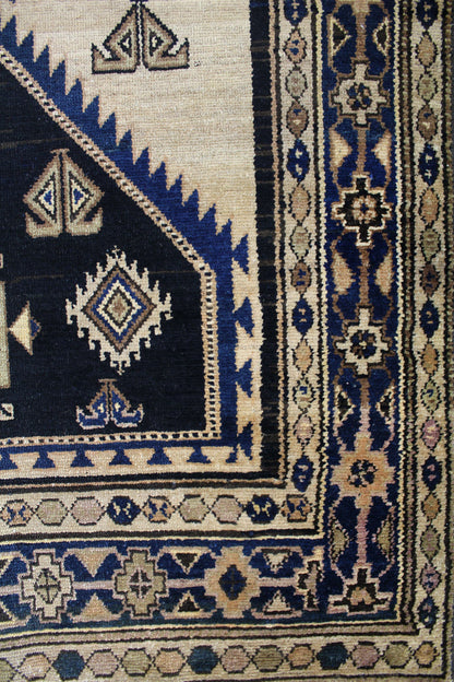 Detail of antique Malayer rug; handwoven tribal design in beige, navy, and brown.
